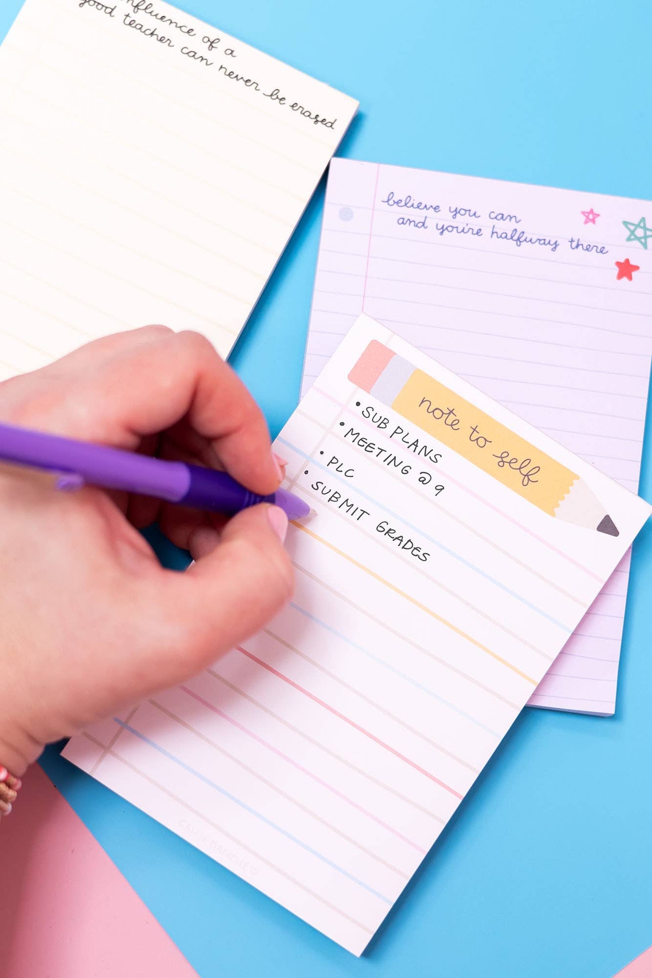 Hand writing on a notepad with a pen on a colorful background