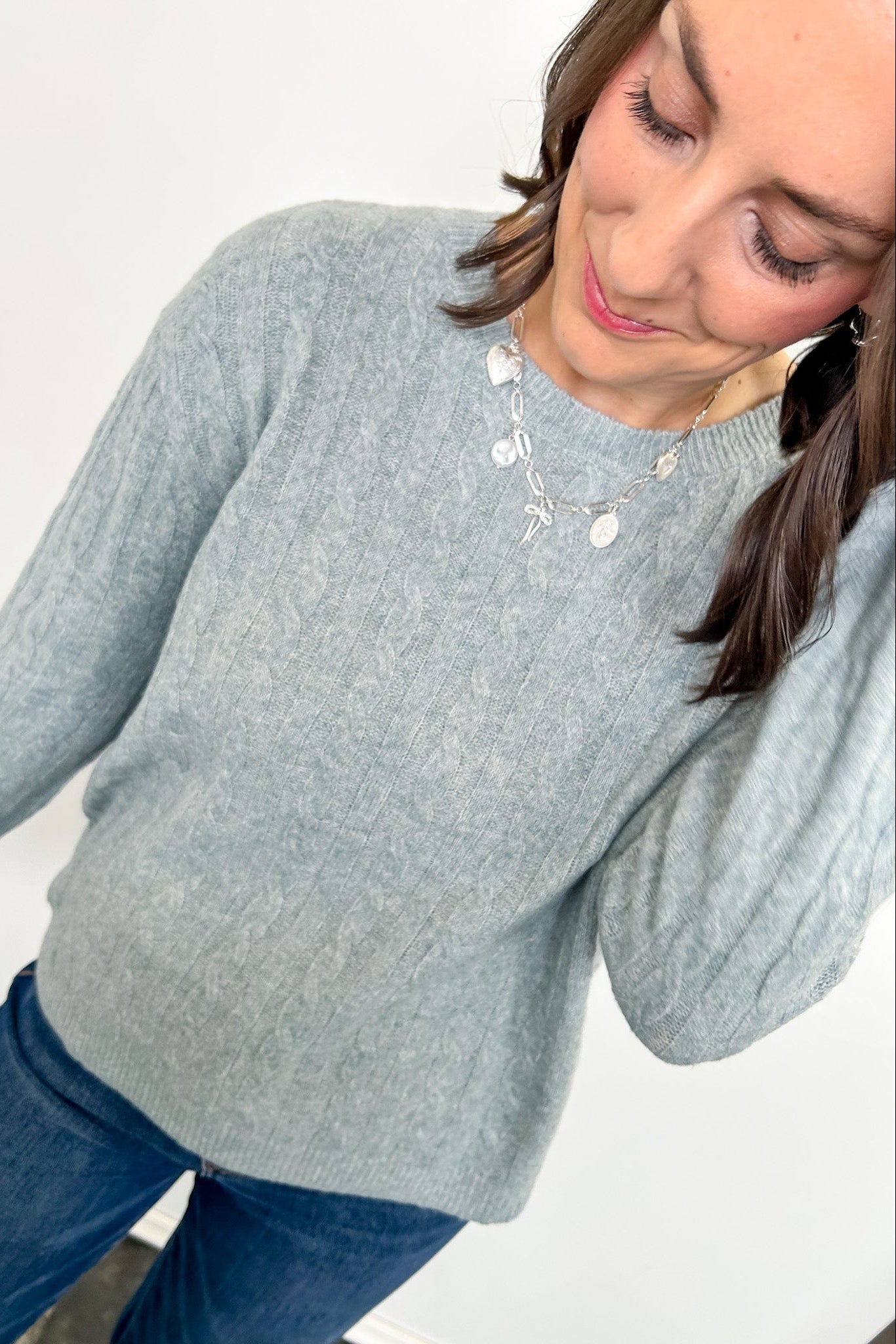 Woman wearing a light blue sweater with a plain background