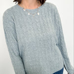 Woman wearing a light blue sweater against a white background