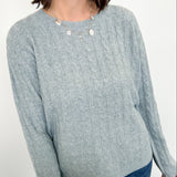 Woman wearing a light blue sweater against a white background
