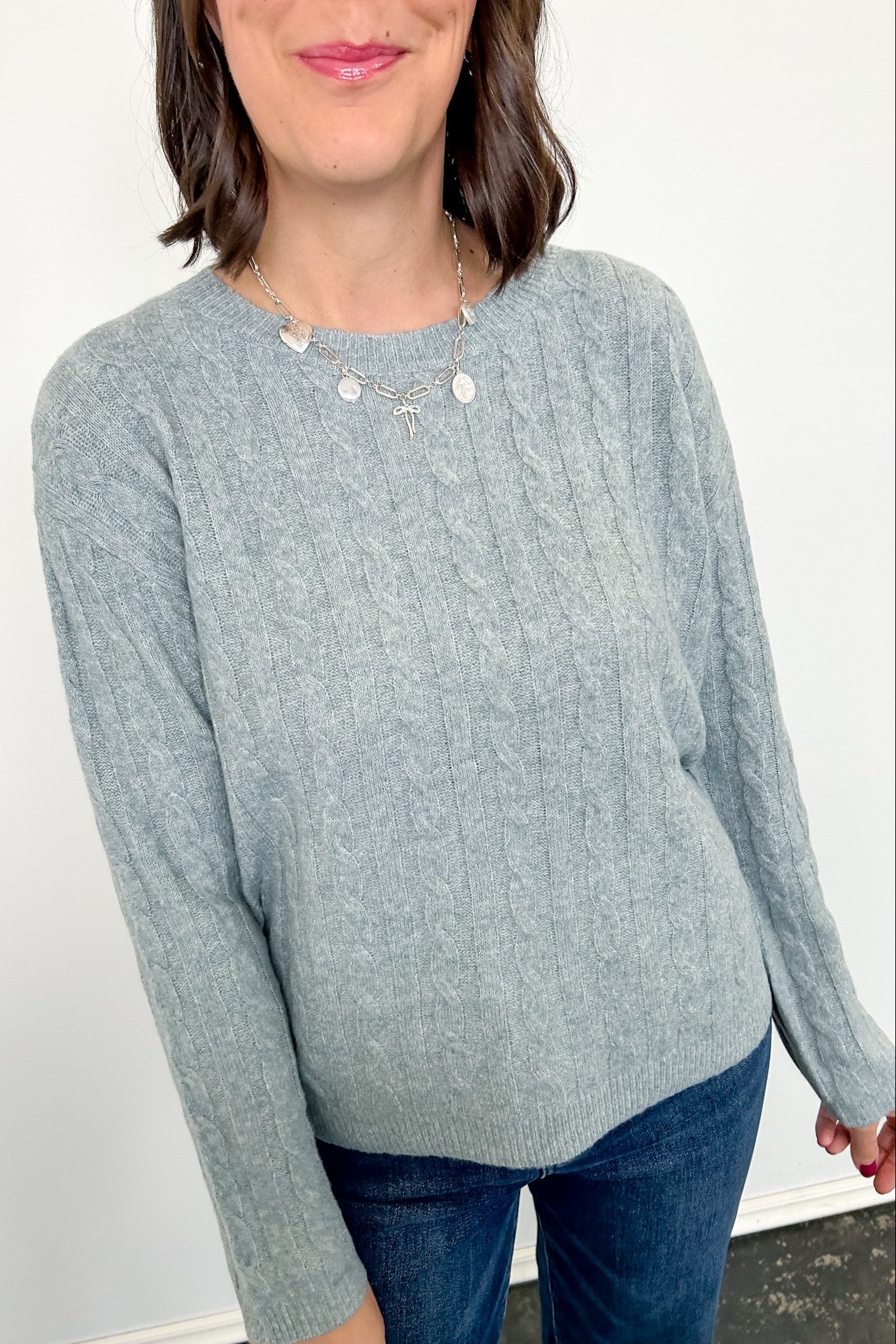 Woman wearing a light blue sweater against a white background