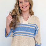 Woman wearing a striped sweater and jeans against a white background
