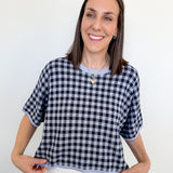 Woman wearing a black and white checkered shirt against a white background