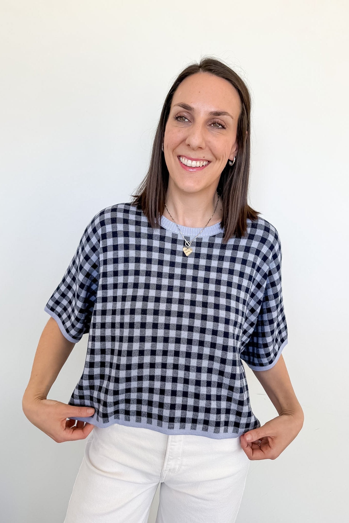 Woman wearing a black and white checkered shirt against a white background