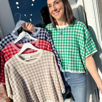 Woman holding a rack of checkered shirts outdoors