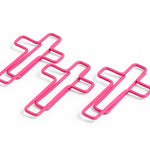 Three pink cross-shaped clips on a white background