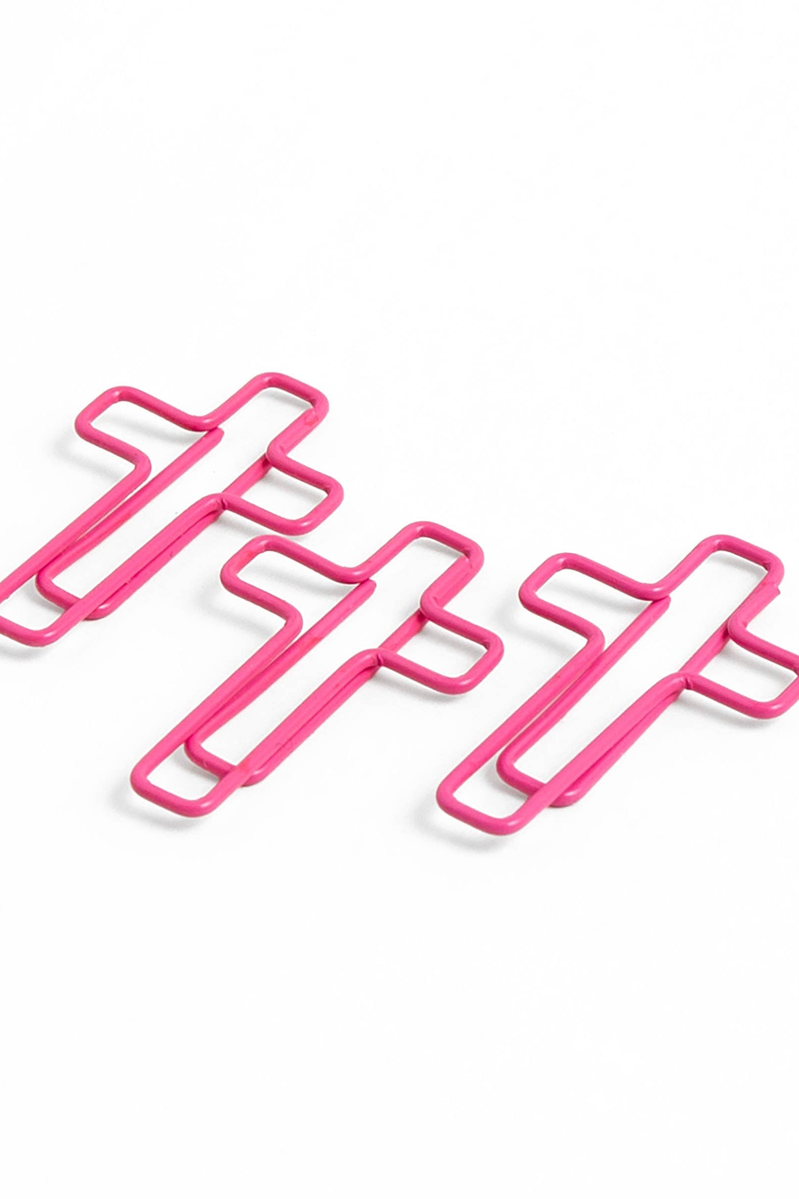 Three pink cross-shaped clips on a white background
