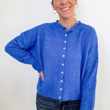 Woman wearing a blue cardigan against a white background