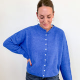 Person wearing a blue cardigan against a white background