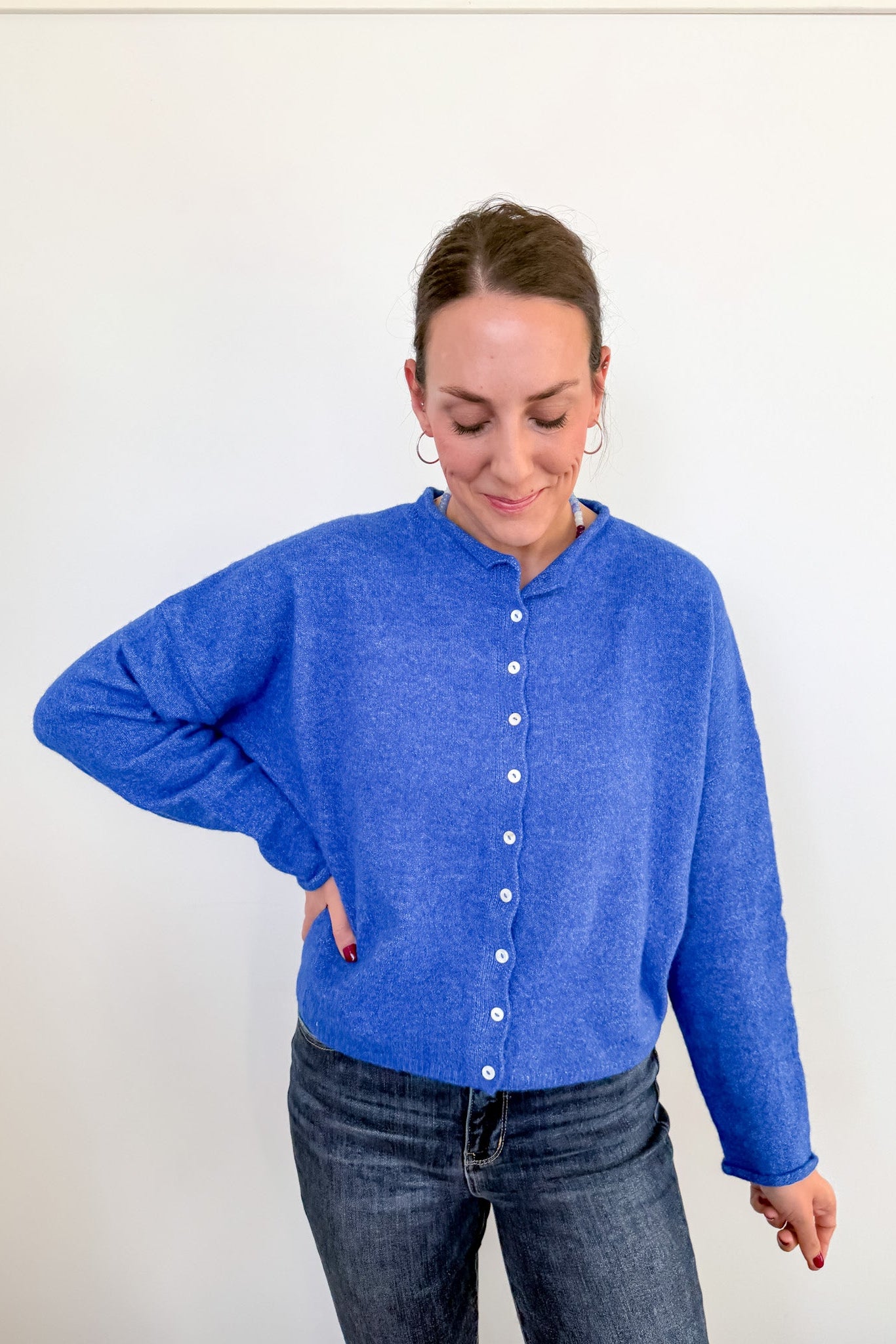 Person wearing a blue cardigan against a white background