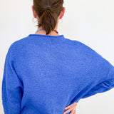 Person wearing a blue sweater from behind on a white background