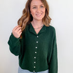 Woman wearing a green sweater with a white background