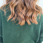 Green fabric with wavy brown hair on a white background