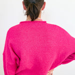 Person wearing a bright pink sweater from behind on a white background