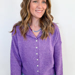 Woman wearing a purple cardigan against a white background