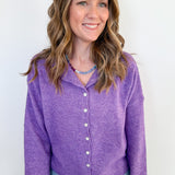 Woman wearing a purple cardigan against a white background
