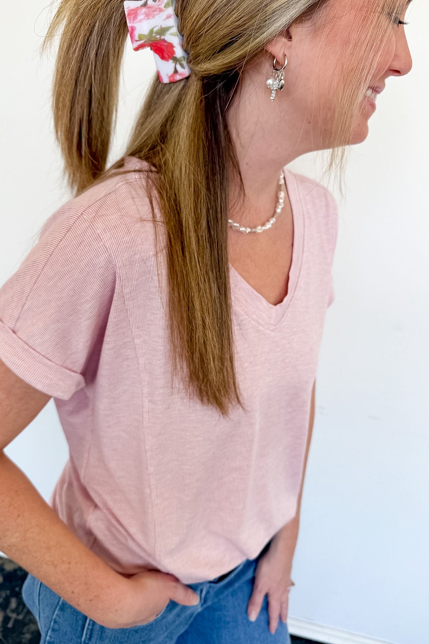 Woman with a floral claw clip in a light pink v neckline tee