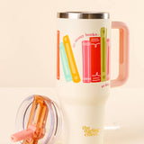 Travel mug with colorful book illustrations and 'the reading effect' branding on a beige background
