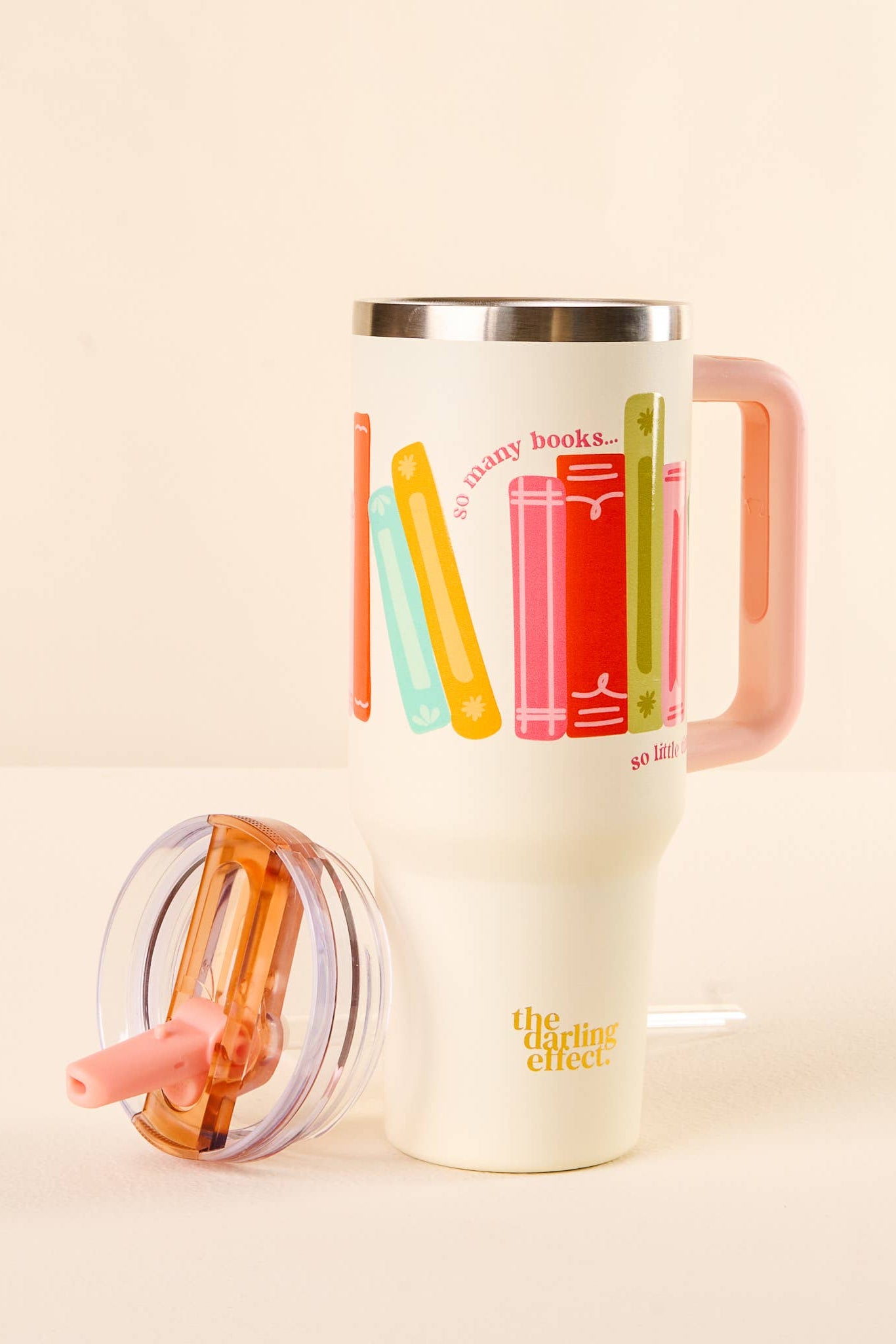 Travel mug with colorful book illustrations and 'the reading effect' branding on a beige background