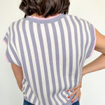 Person wearing a striped shirt and jeans against a white background