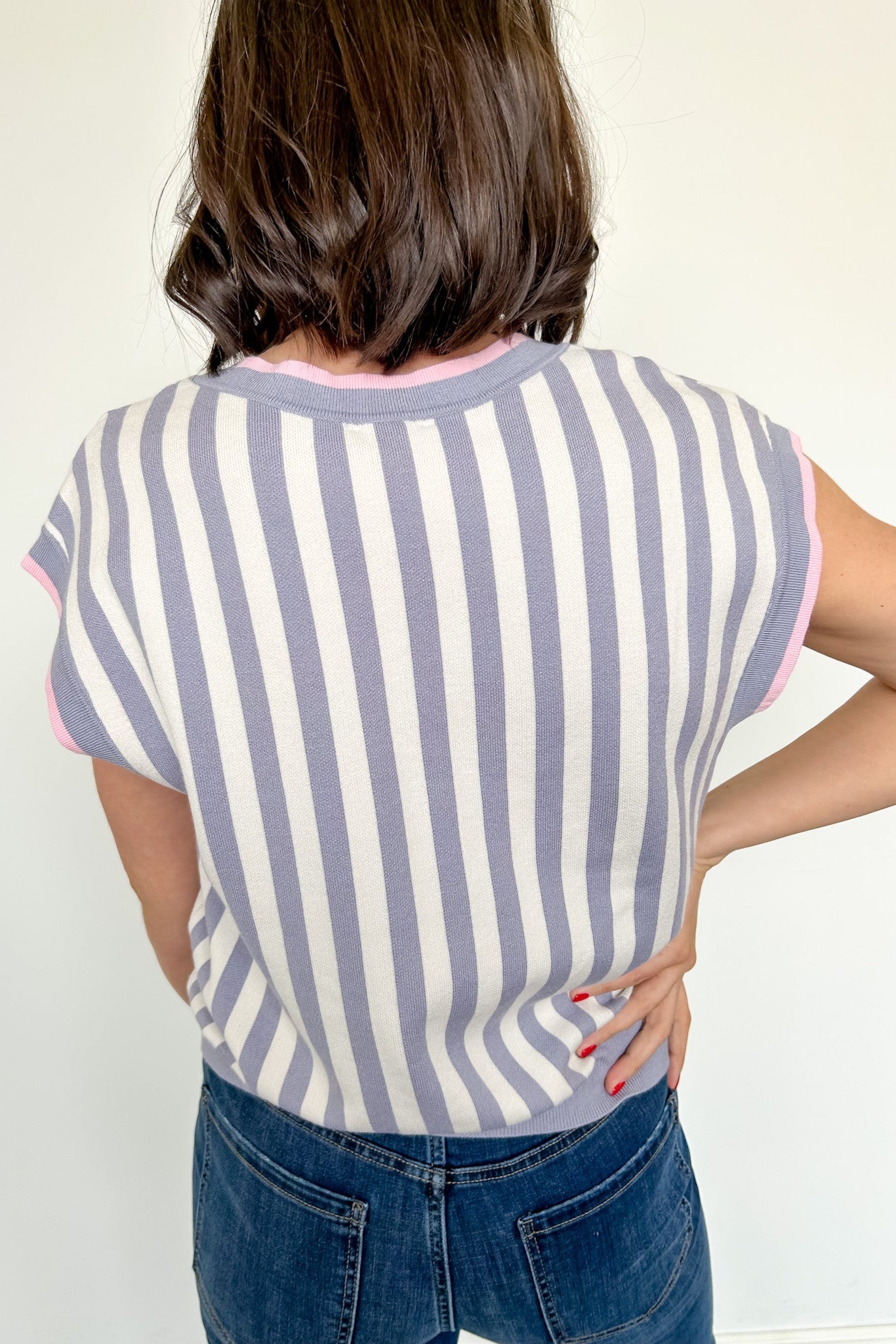 Person wearing a striped shirt and jeans against a white background