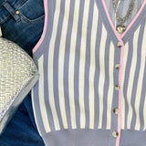 Striped cardigan with jeans and a silver handbag on a white background