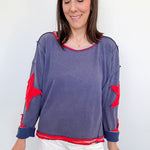 Woman wearing a blue sweater with red accents on a white background