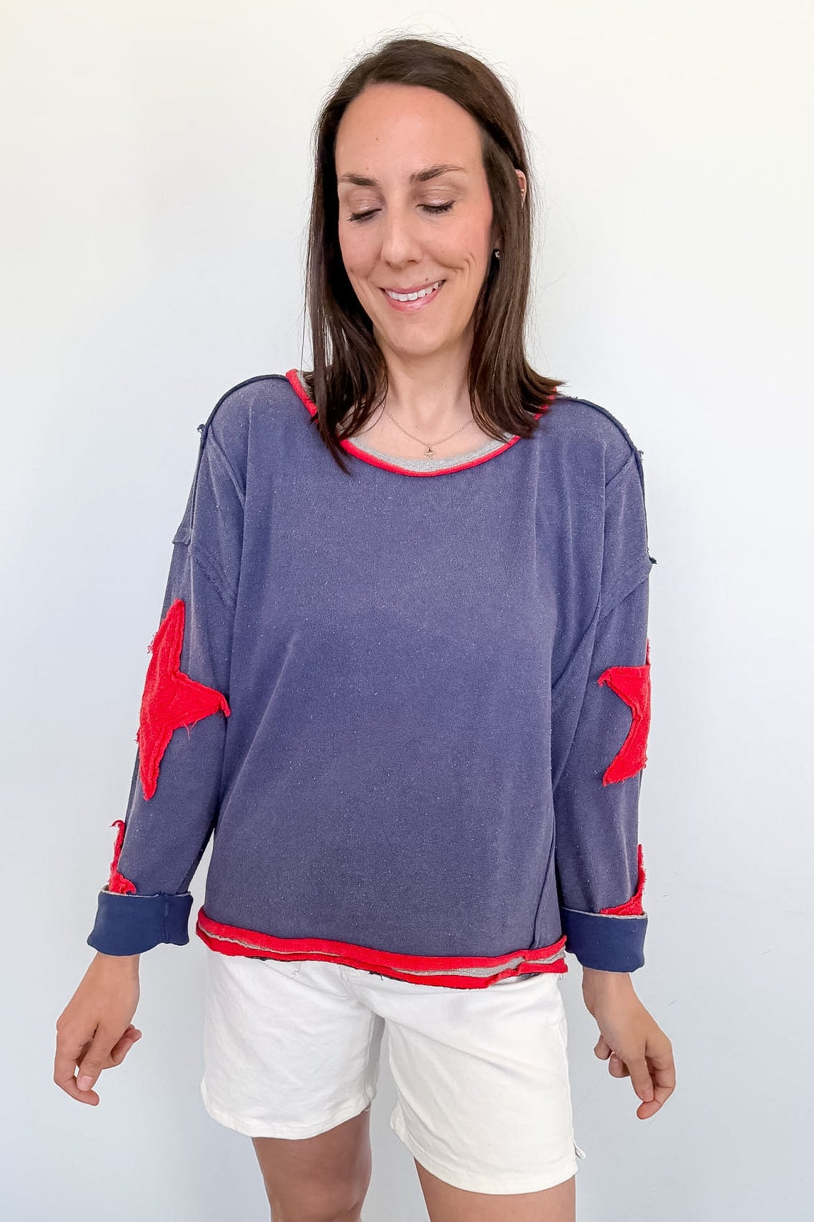 Woman wearing a blue sweater with red accents on a white background