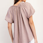 Mauve colored top with a v neckline and puff sleeve detailing. Regular fitting top. Blouse style.