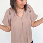Mauve colored top with a v neckline and puff sleeve detailing. Regular fitting top. Blouse style.