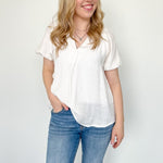 White colored top with a v neckline and puff sleeve detailing. Regular fitting top. Blouse style.