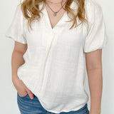 White colored top with a v neckline and puff sleeve detailing. Regular fitting top. Blouse style.