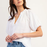 White colored top with a v neckline and puff sleeve detailing. Regular fitting top. Blouse style.