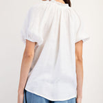 White colored top with a v neckline and puff sleeve detailing. Regular fitting top. Blouse style.