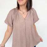 Mauve colored top with a v neckline and puff sleeve detailing. Regular fitting top. Blouse style.