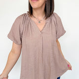 Mauve colored top with a v neckline and puff sleeve detailing. Regular fitting top. Blouse style.