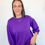 Woman wearing a purple sweatshirt against a white background
