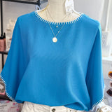 Blue sweater on a mannequin with a blurred store background