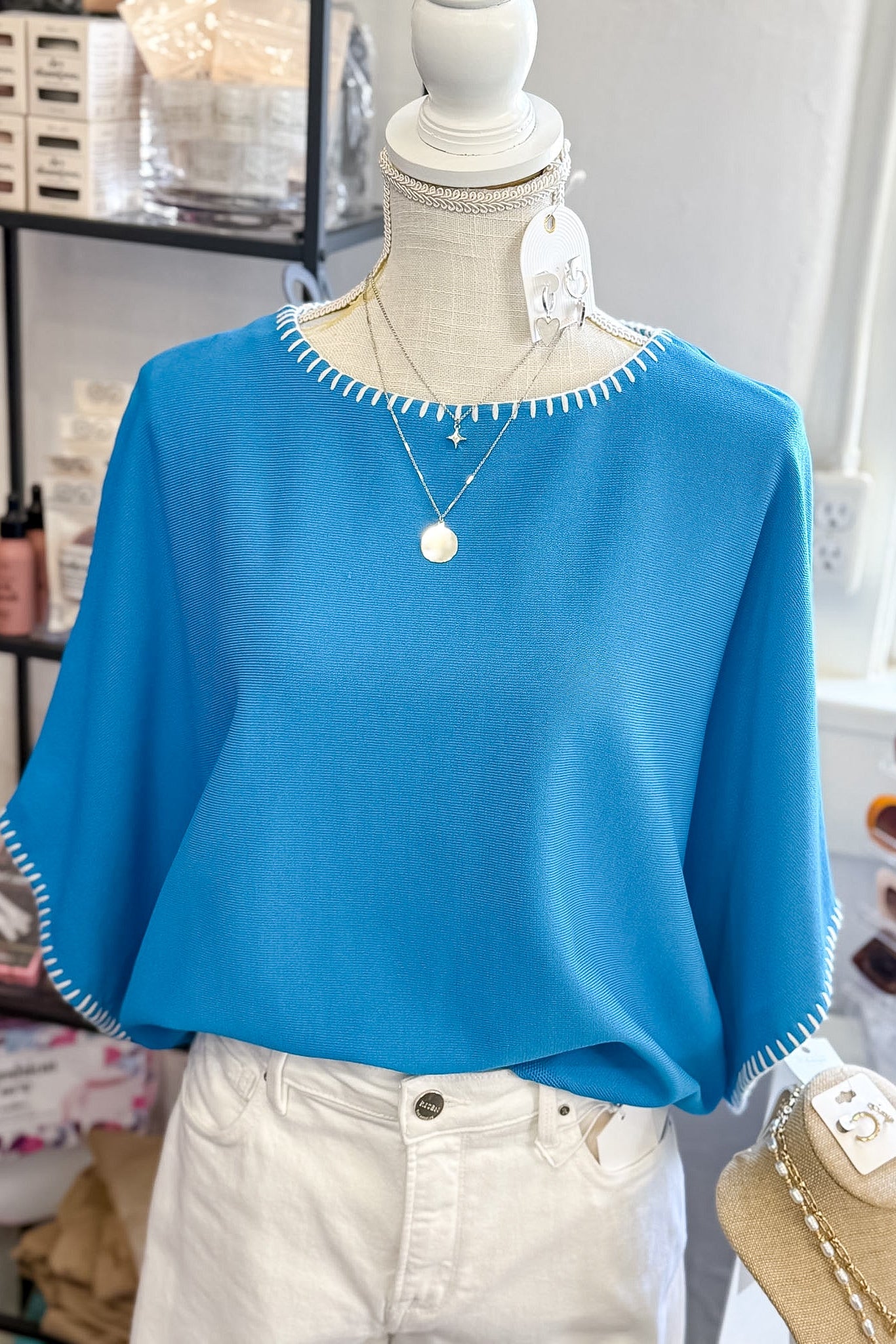 Blue sweater on a mannequin with a blurred store background