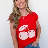 Woman wearing a red sleeveless top with white cherries on a plain background
