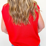 Person wearing a red sleeveless top and blue jeans against a white background
