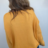 Person wearing a mustard yellow jacket on a white background