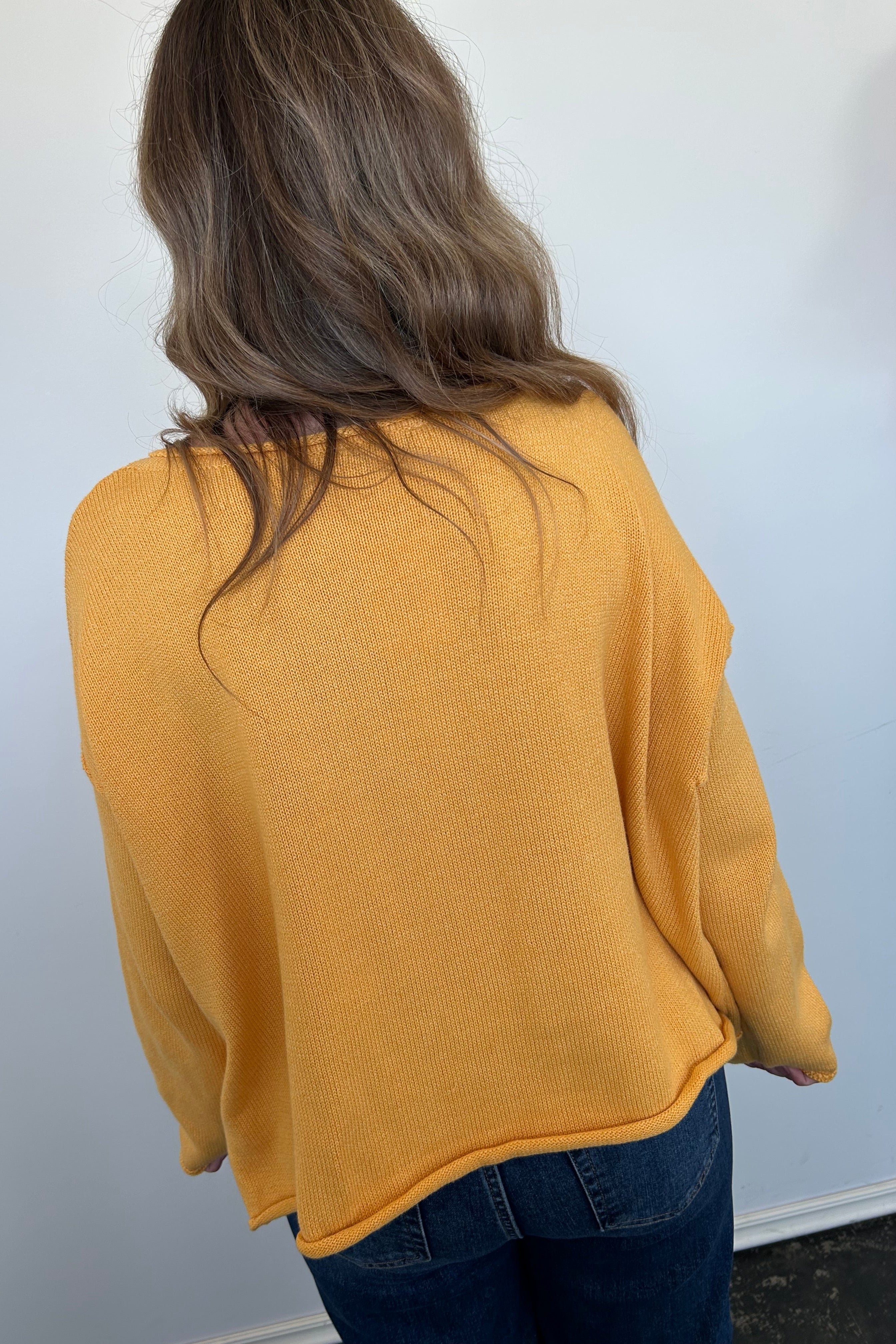 Person wearing a mustard yellow jacket on a white background
