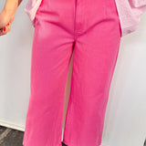 Person wearing bright pink pants with a white background