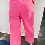 Person wearing pink pants and a checkered shirt in an indoor setting.