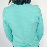 Person wearing a light blue long-sleeve shirt and jeans against a white background