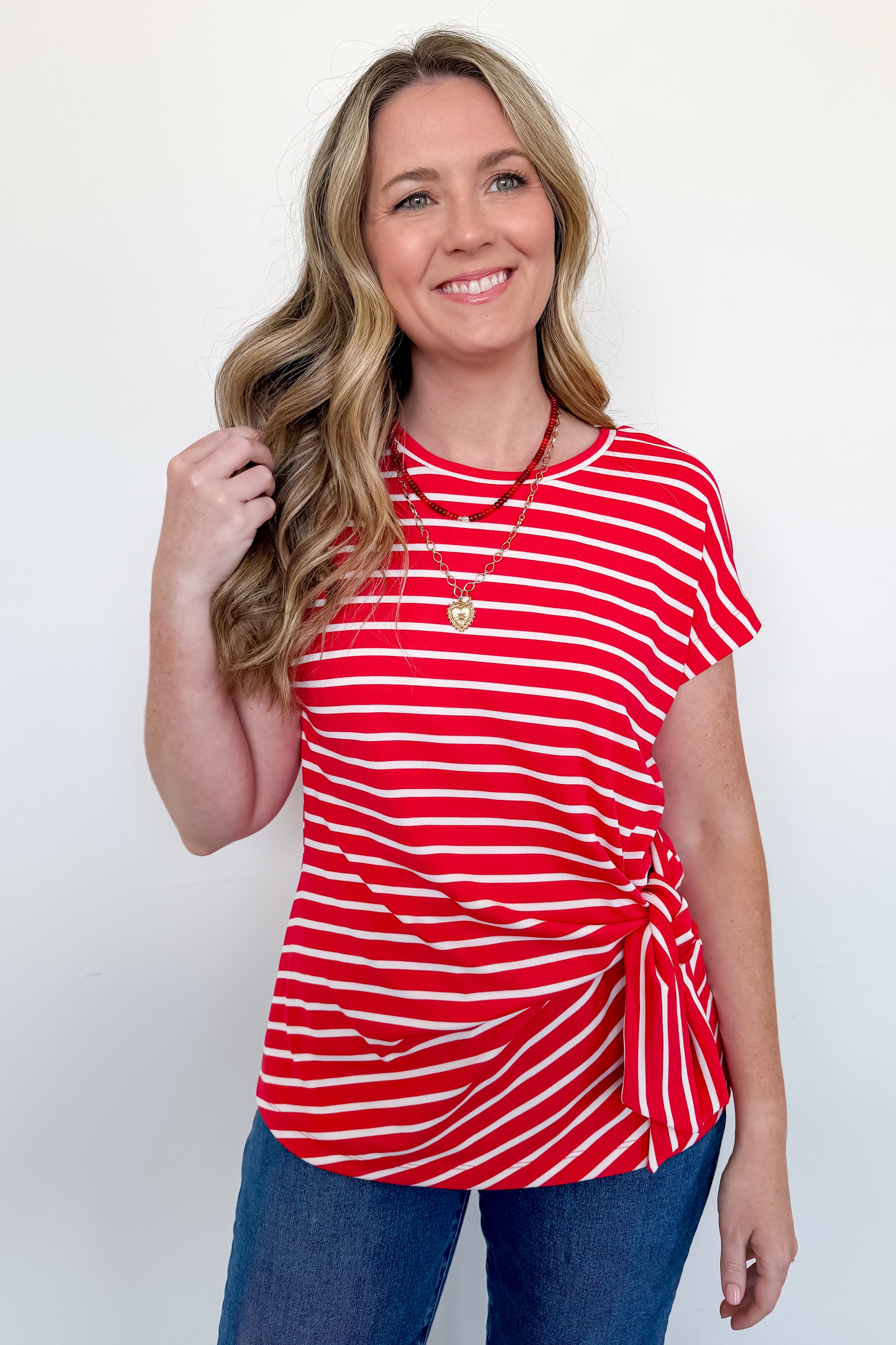 Woman wearing a red and white striped top against a white background