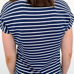 Person wearing a navy and white striped shirt on a plain background