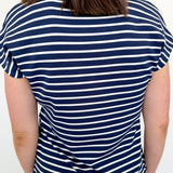 Person wearing a navy and white striped shirt on a plain background
