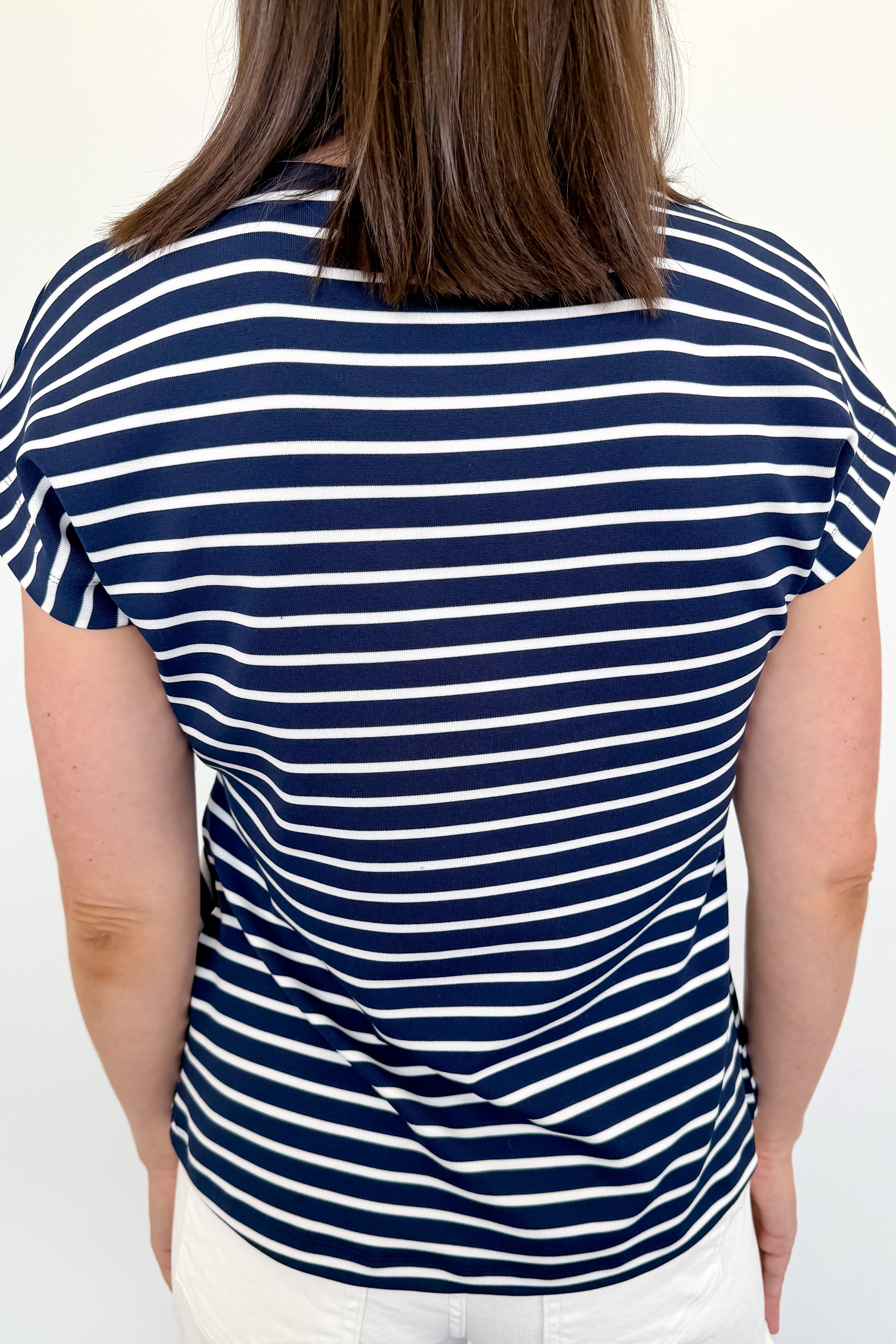 Person wearing a navy and white striped shirt on a plain background